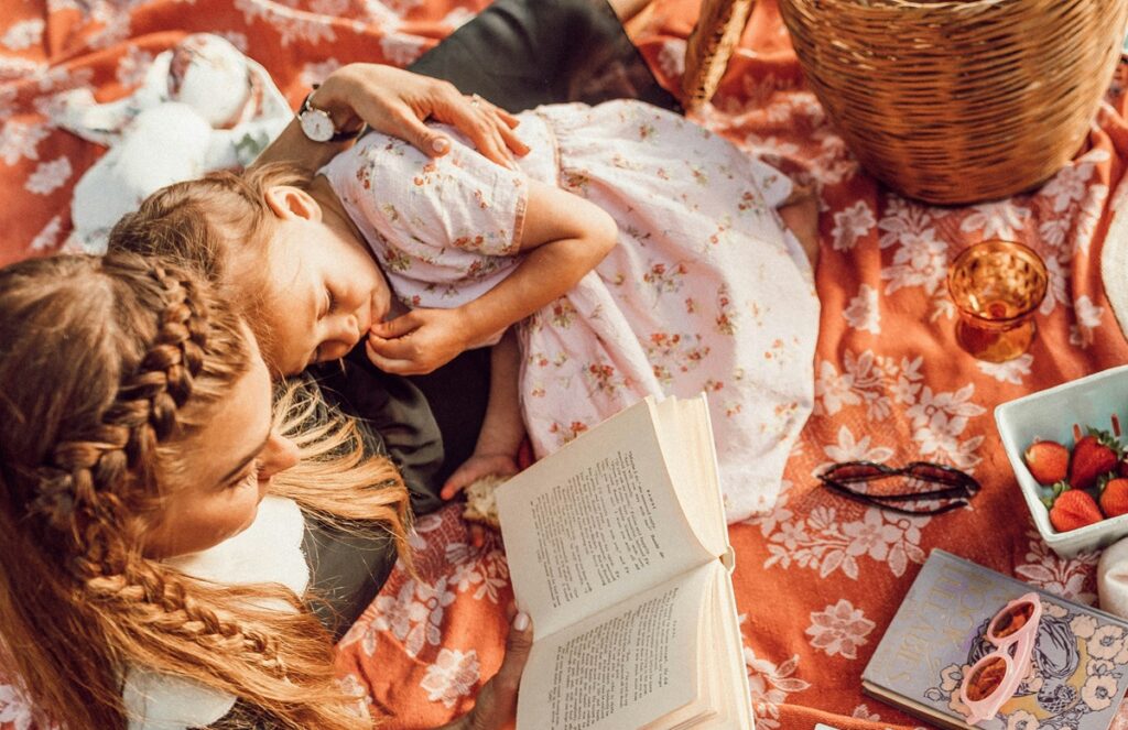 本を読みながらくつろぐ母親と女の子