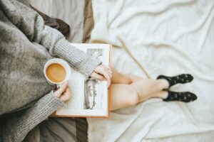 コーヒーを片手に本を読む女性